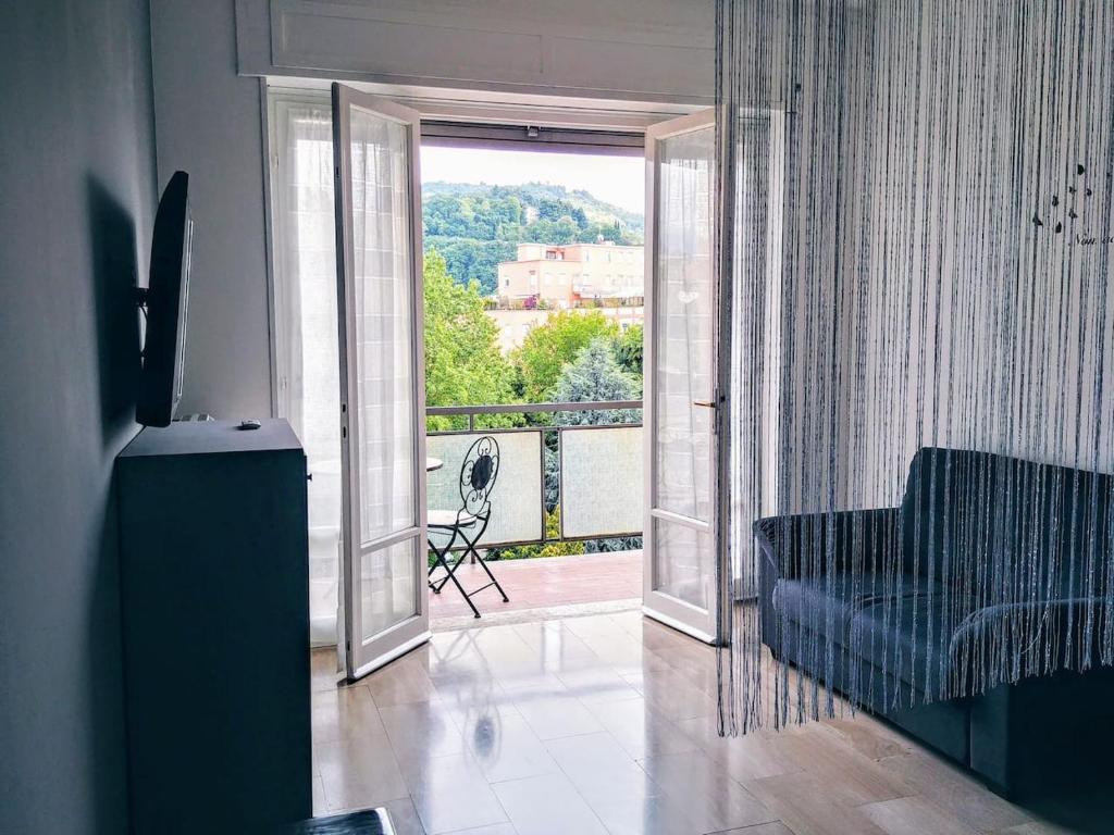 布雷西亚Appartamento con terrazzo zona ospedale civile的带沙发的客厅和阳台美景