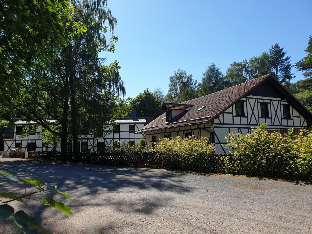 Gernrode - HarzSternhaus-Harz的白色和黑色的房子,有栅栏和树木