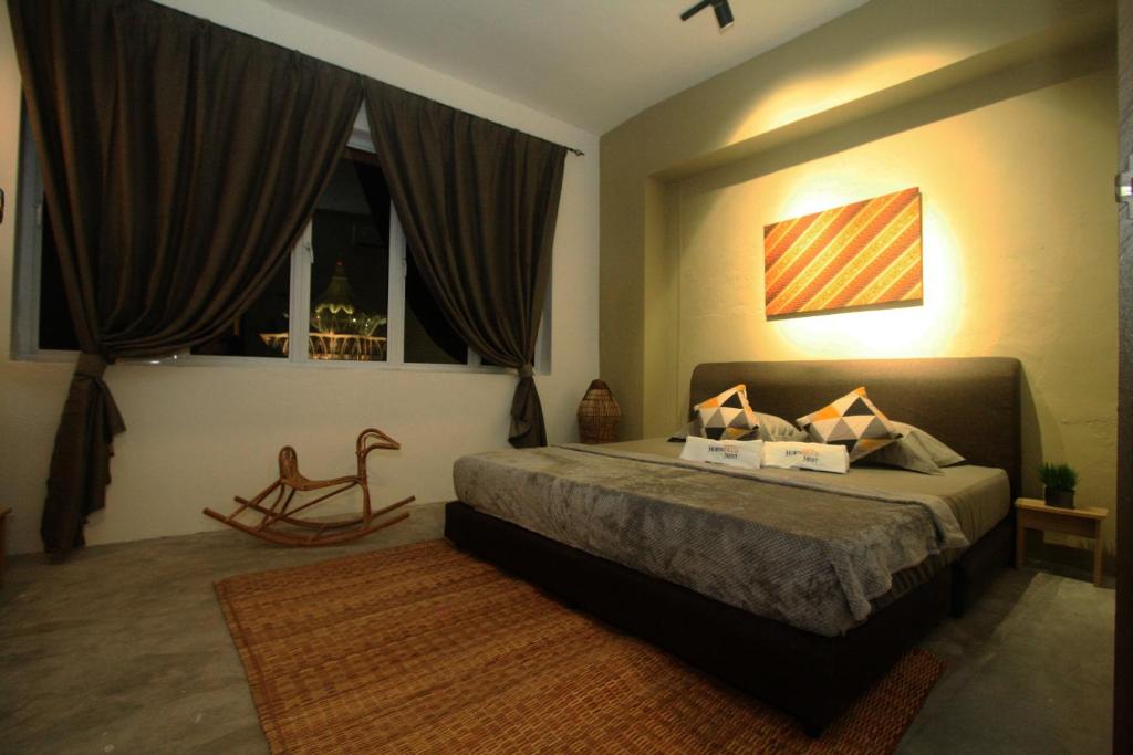 古晋Hornbill's Nest Kuching的一间卧室设有一张床、一个窗口和一把椅子