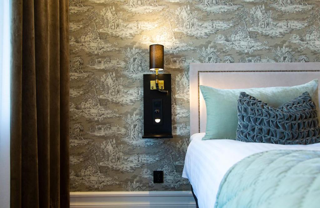 斯塔德大陆南方酒店的一间卧室配有一张床,墙上配有一盏灯