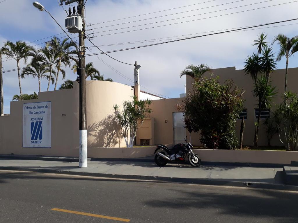 伊利亚孔普里达Associação Sabesp Ilha Comprida的停在大楼前人行道上的摩托车