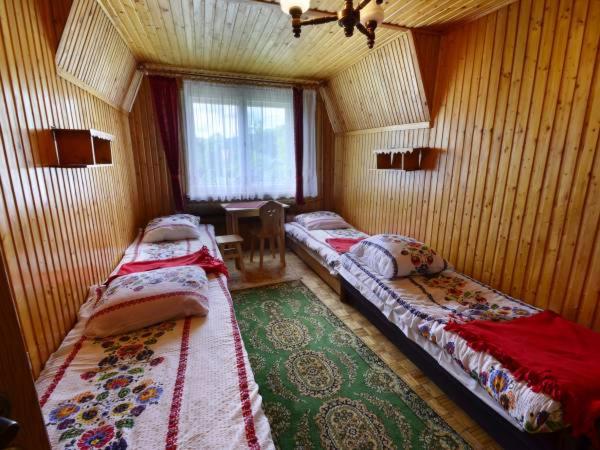 扎沃亚Trybałowa Ostoja的带四张床的客房,位于带窗户的房间内