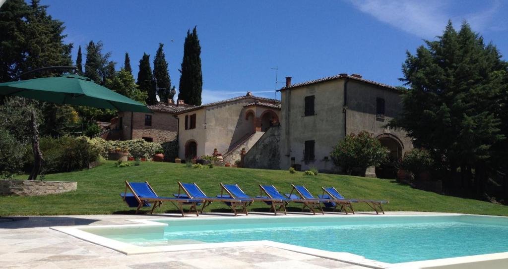 圣焦万尼达索Casale Le Borghe - Montalcino,Toscana的一组蓝色的躺椅,位于房子旁边