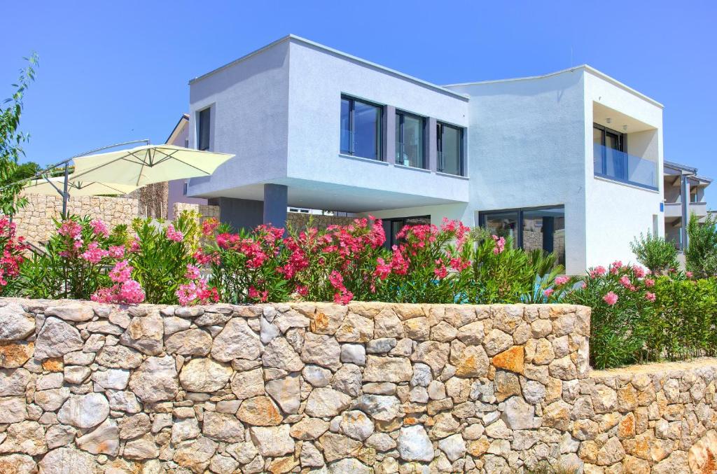 克尔克Villa Silente的一座石墙和粉红色花卉的房子