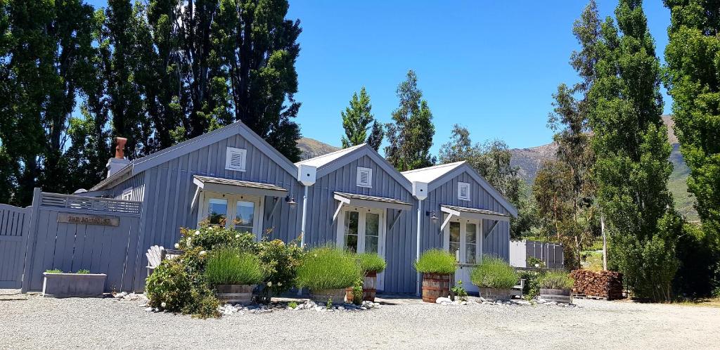 GibbstonGibbston Boathouse with Outdoor Bath的种有盆栽植物和树木的灰色房子