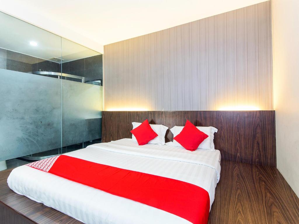 Kampong Batu BelahSuper OYO 340 Comfort Hotel的一间卧室配有一张带红色枕头的大床