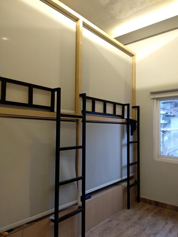 勒吉安XOXO Kuta Legian Hostel的客房设有两张双层床和白色板