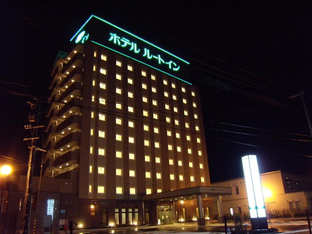 鹤冈市鹤冈站前路线酒店的一座建筑物,上面有夜间标志