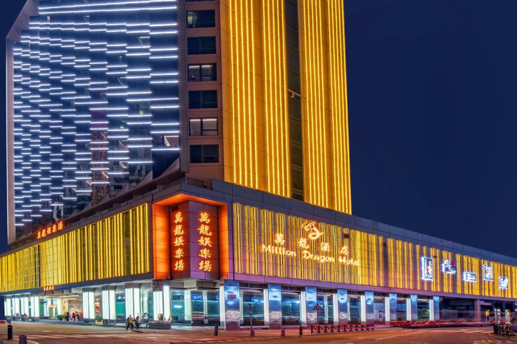 澳门City Viva Hotel Macau-Fomerly Hotel Million Dragon Macau的一座高大的建筑,晚上有灯