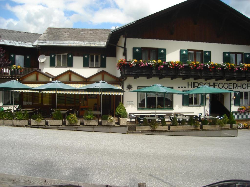 Hirschegg Rein海尔施格尔霍夫酒店的前面有桌子和伞的建筑
