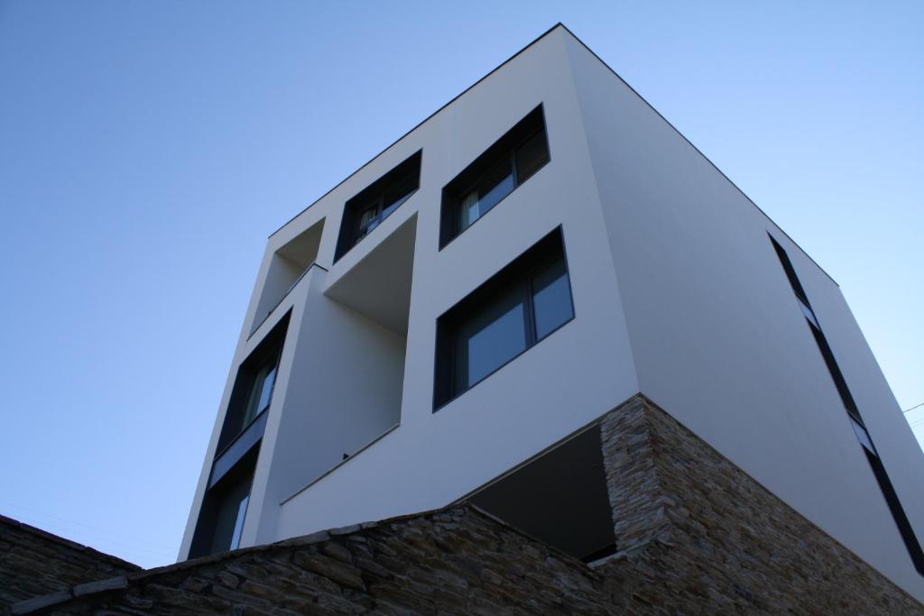 维拉弗兰卡·德尔·比尔特雷斯纳斯旅馆的砖砌建筑顶部的白色建筑,设有窗户