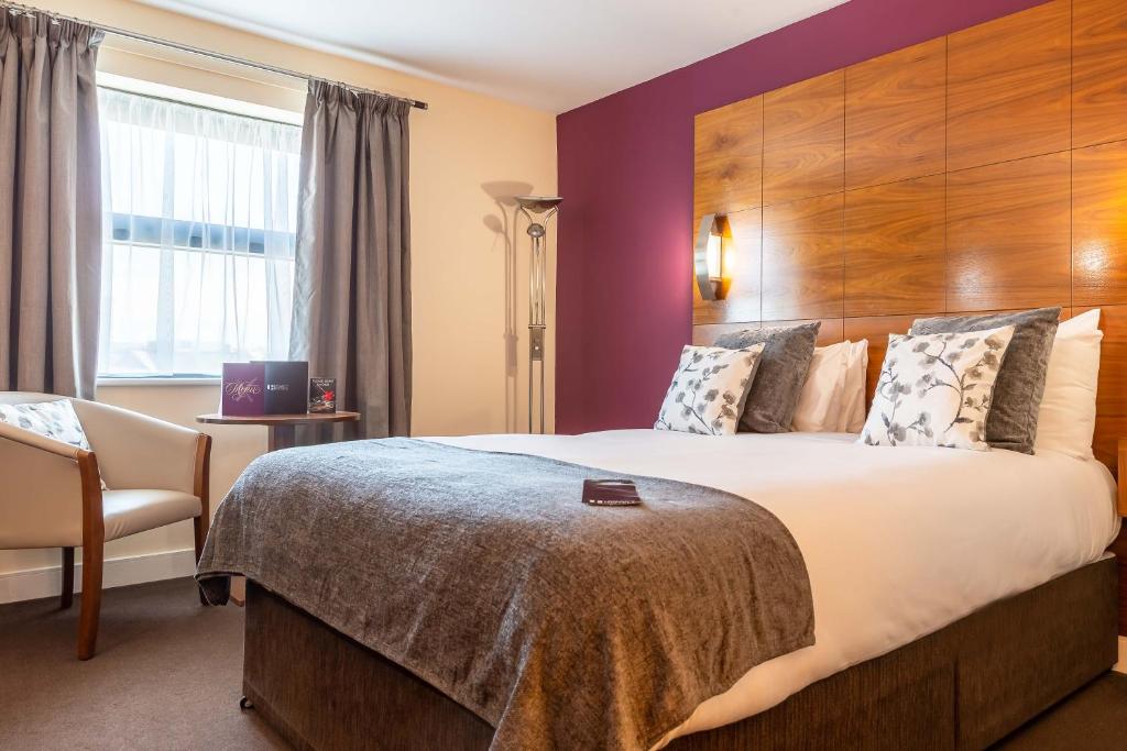 普雷斯顿传统普雷斯顿国际酒店的酒店客房带一张大床和一把椅子