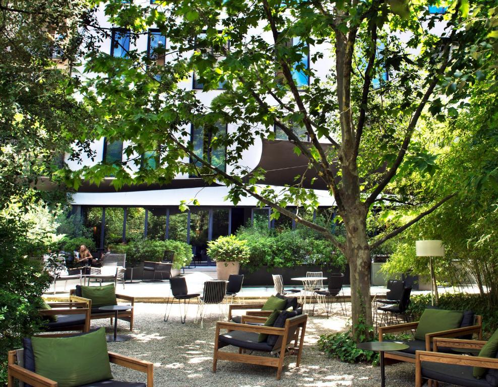 巴塞罗那巴塞罗那GL阿尔玛酒店的庭院配有桌椅和一棵树