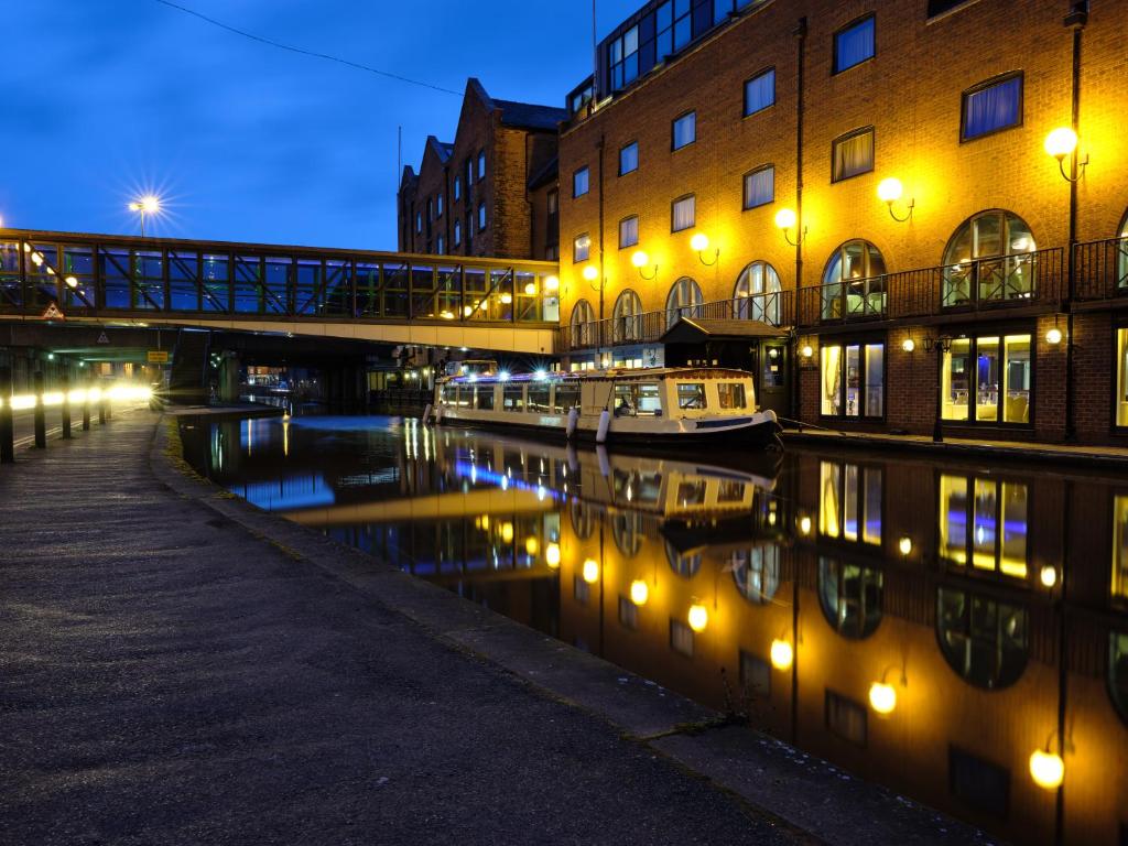 切斯特MILL Hotel & Spa的一条运河,有桥梁,建筑和小船