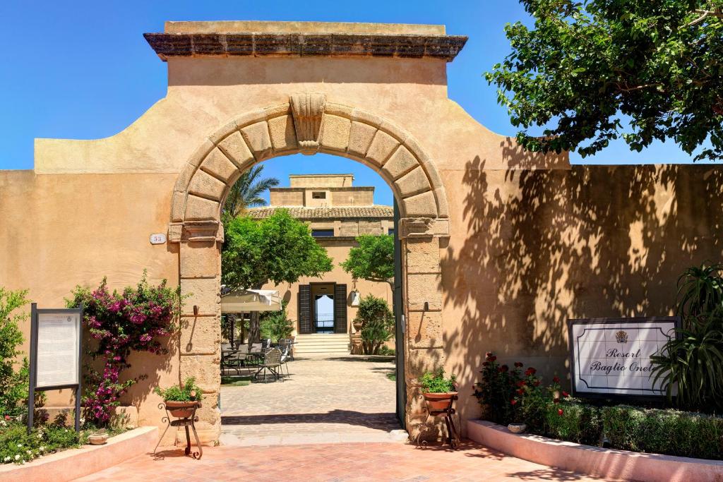 马尔萨拉Hotel Baglio Oneto dei Principi di San Lorenzo - Luxury Wine Resort的拱门,后面有一座建筑