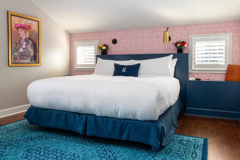 纳什维尔The Germantown Inn的一间卧室设有一张大床,拥有蓝色和粉红色的墙壁