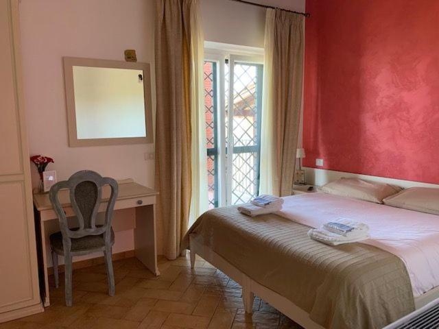 Castel San Pietro Romano森杰里艾4号住宿加早餐旅馆的一间卧室配有一张床、一张书桌和一个窗户。
