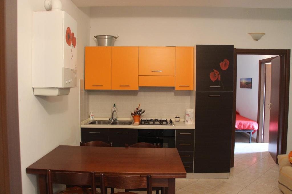 诺切劳恩布拉Sul sentiero di Francesco的厨房配有橙色橱柜和木桌