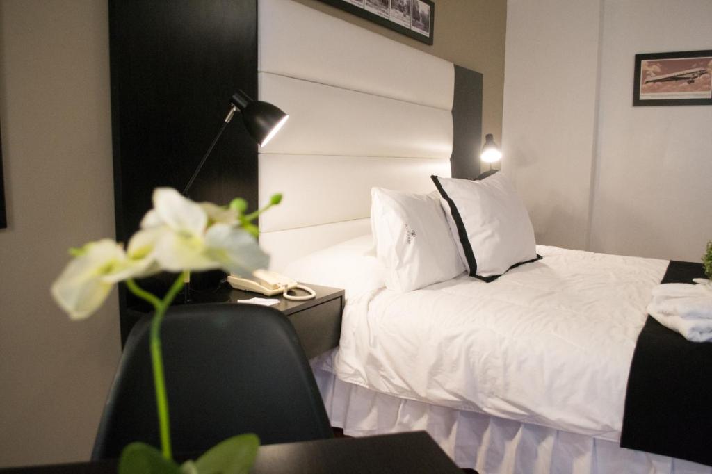 蒙得维的亚波西托斯广场酒店的酒店客房配有一张床、一张书桌和一部电话