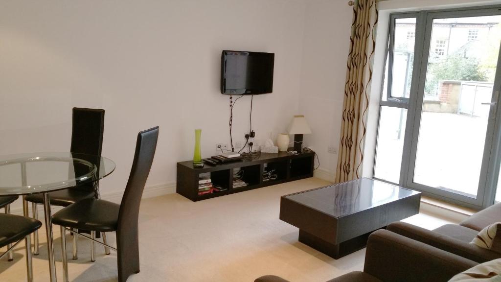 牛津Oxford Apartment-- Free parking 2 Bedrooms-2Bathrooms-Located in Jericho Oxford close to Bus and Rail station的带沙发、桌子和电视的客厅