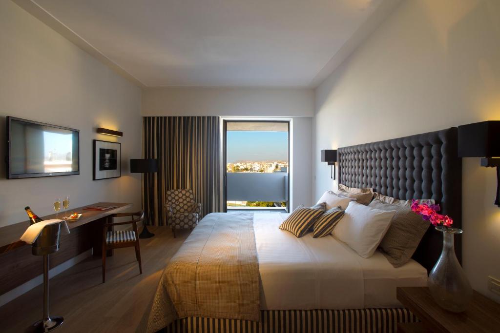 海若克利欧拉奎拉亚特兰蒂斯酒店的一间卧室配有一张带书桌的床和窗户。