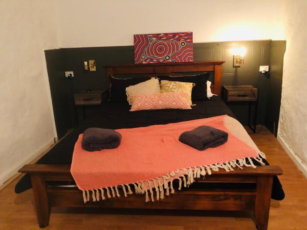 库伯佩迪The Blacklighters Opal Retreat-Undergound的一间卧室配有一张大床和两条毛巾