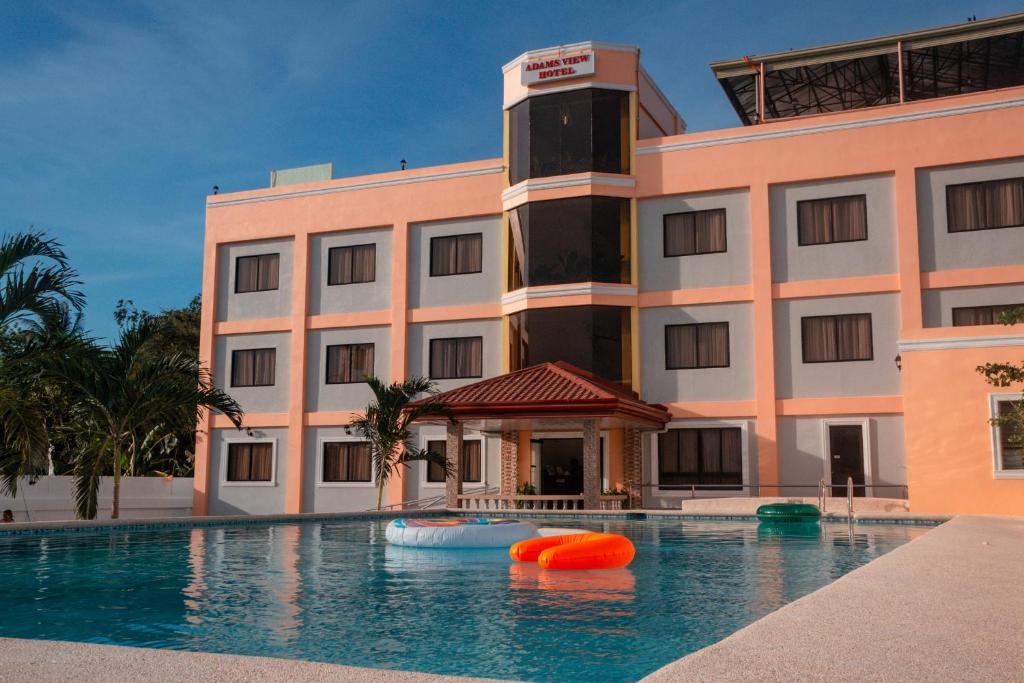 莫阿尔博阿Adams View Hotel的大楼前设有游泳池的酒店