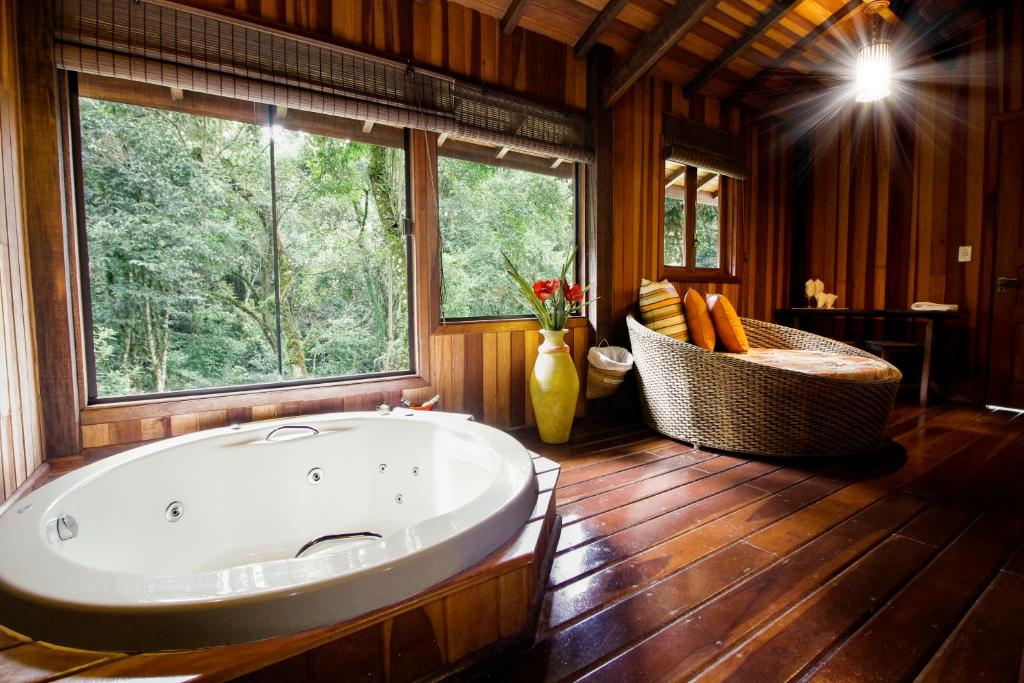 蒙特韦尔迪Pousada Ahavanoah的大型浴室设有大浴缸和窗户。