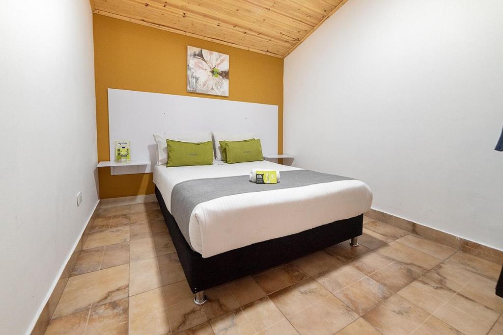 波哥大Hotel Casa Normandia的一间卧室配有一张带绿色枕头的大床