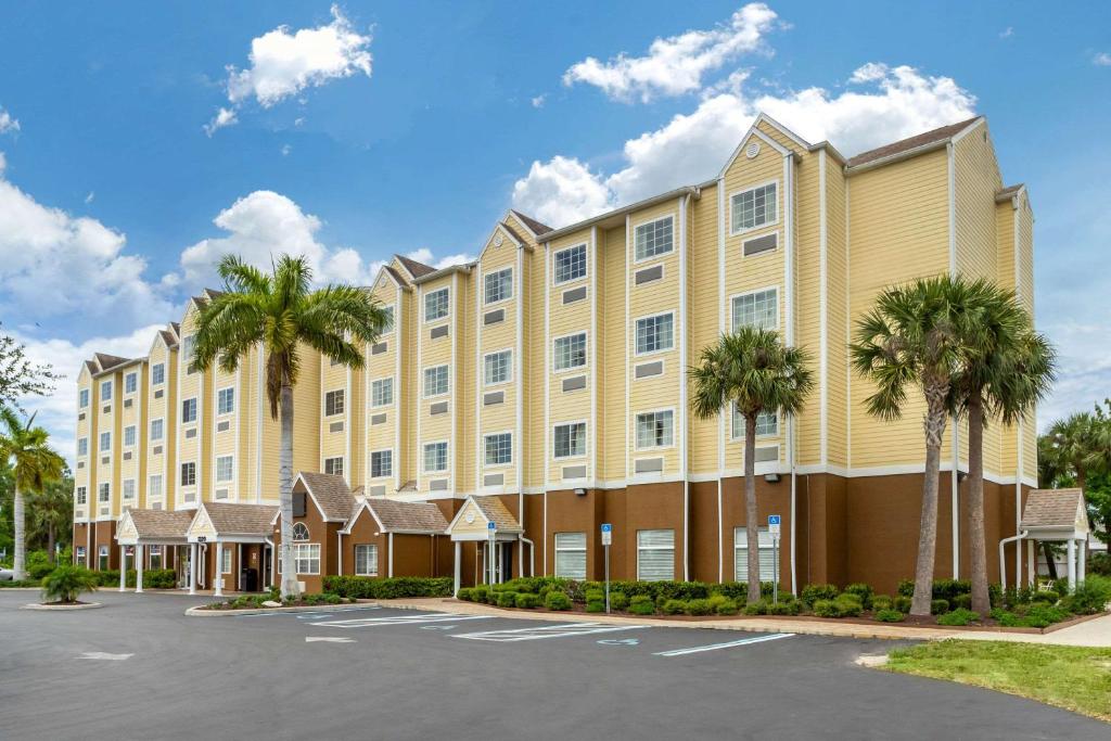 利哈伊埃克斯Quality Inn & Suites Lehigh Acres Fort Myers的停车场内棕榈树的大型建筑