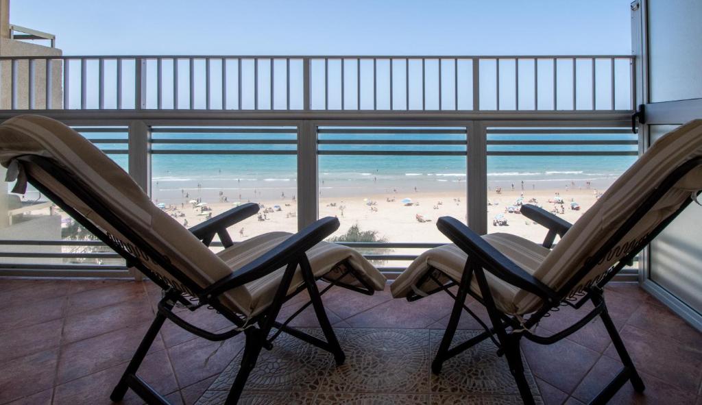 加的斯Apartamento Paseo Maritimo 27的享有海滩景致的客房内设有两把椅子