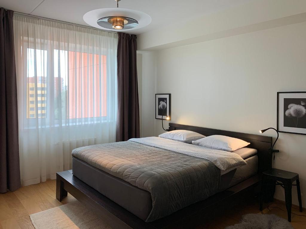 塔林Orange Sipelga Balcony & Free Parking的一间卧室设有一张床和一个大窗户