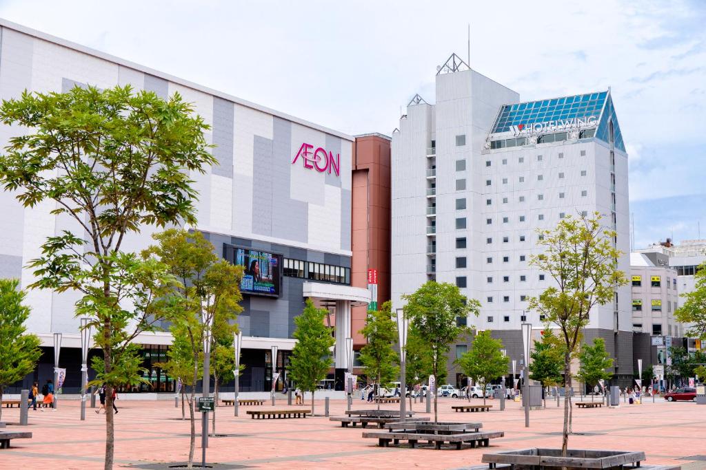 旭川Hotel Wing International Asahikawa Ekimae的城市中一群有长椅的建筑