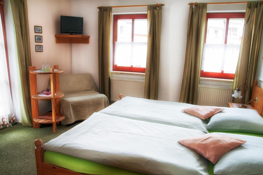 克林根塔尔Frühstücks Pension Zum Postillion的一间卧室配有一张床、一把椅子和窗户。