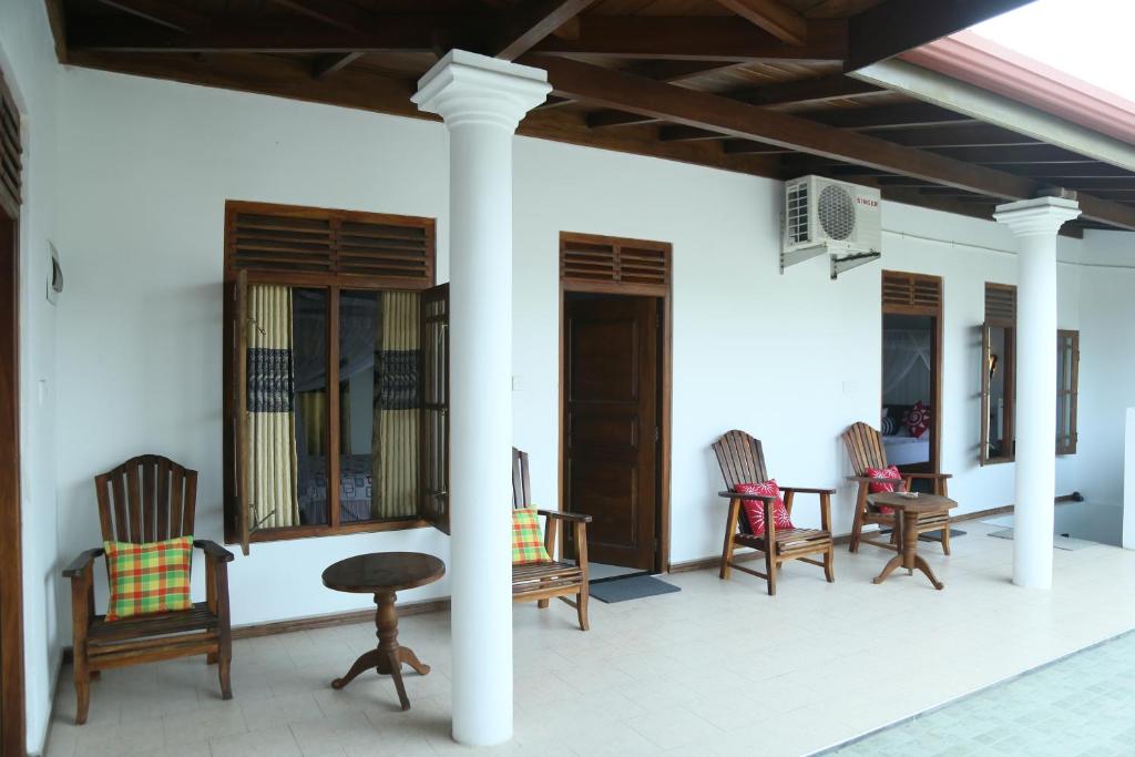 肯克拉Villa Koggala的门廊配有摇椅和桌子