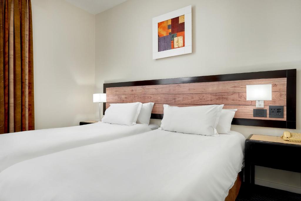约翰内斯堡ANEW Hotel Parktonian Johannesburg的酒店客房配有一张带白色枕头的大床