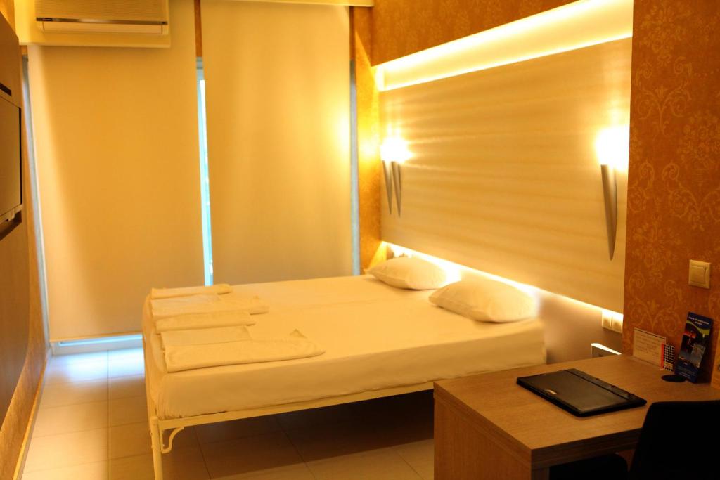 苏达Oneiro Suites的小房间设有一张床和一张书桌