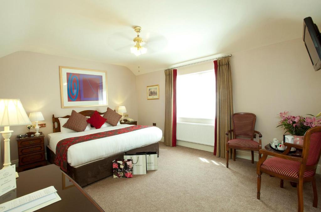 都柏林海灵顿大厅酒店的酒店客房,配有一张床、一张桌子和椅子