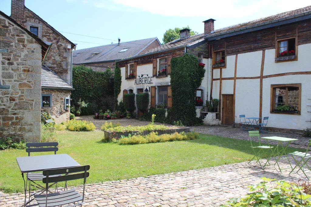 FanzelAuberge du Val d'Aisne的一座带桌椅的花园位于一座建筑前