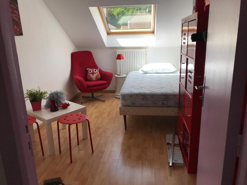 Plancher-les-MinesRésidence de l’ex hôtel des roches的一间小卧室,配有一张床和一把红色椅子