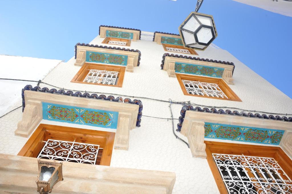 拉巴特Riad Najiba的一座拥有色彩缤纷的窗户和街灯的建筑