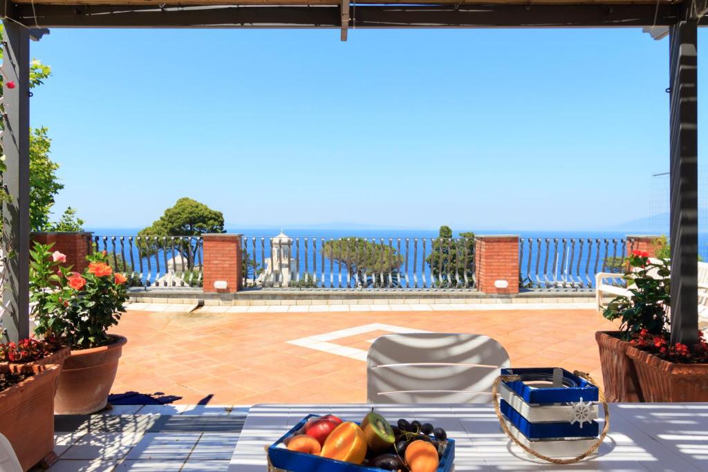 卡普里AQUAMARINE Relaxing Capri Suites的露台上的一张桌子,上面放着水果和蔬菜托盘