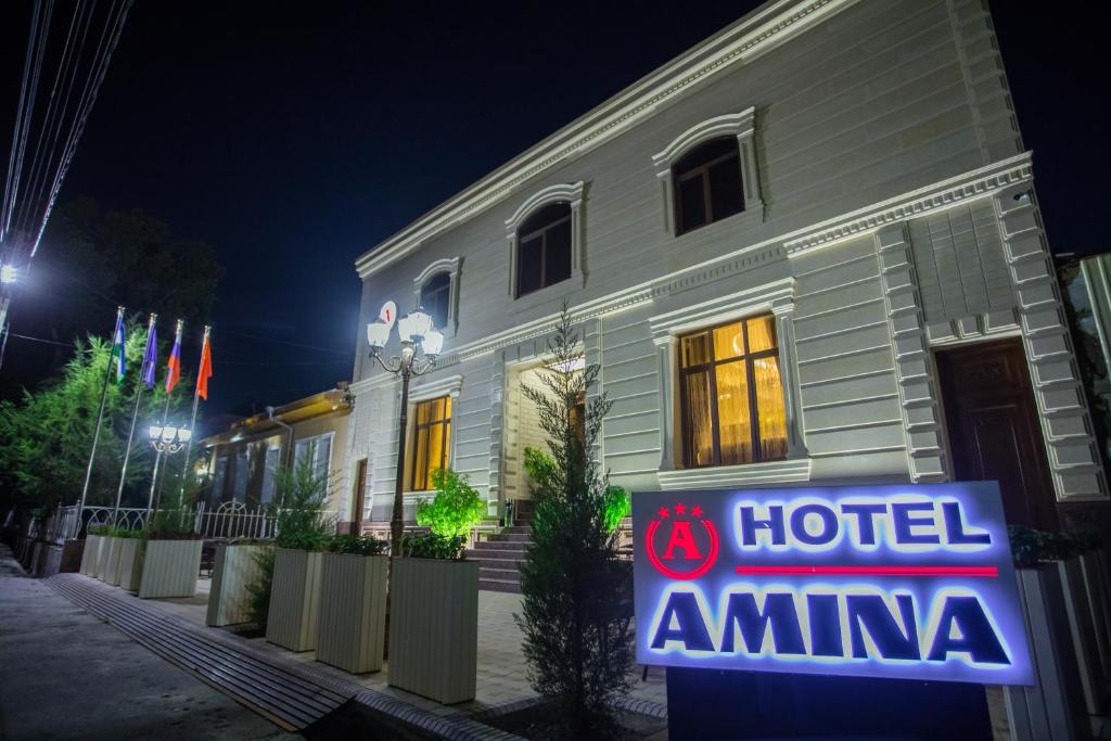 撒马尔罕Amina hotel的大楼前的旅馆绿花标志