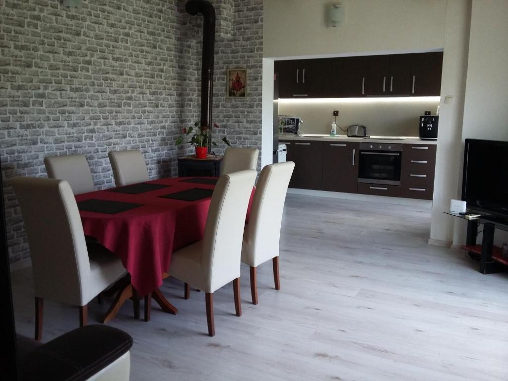 圣君士坦丁和海伦那Villa Sunny Day的一间设有红色桌子和白色椅子的用餐室