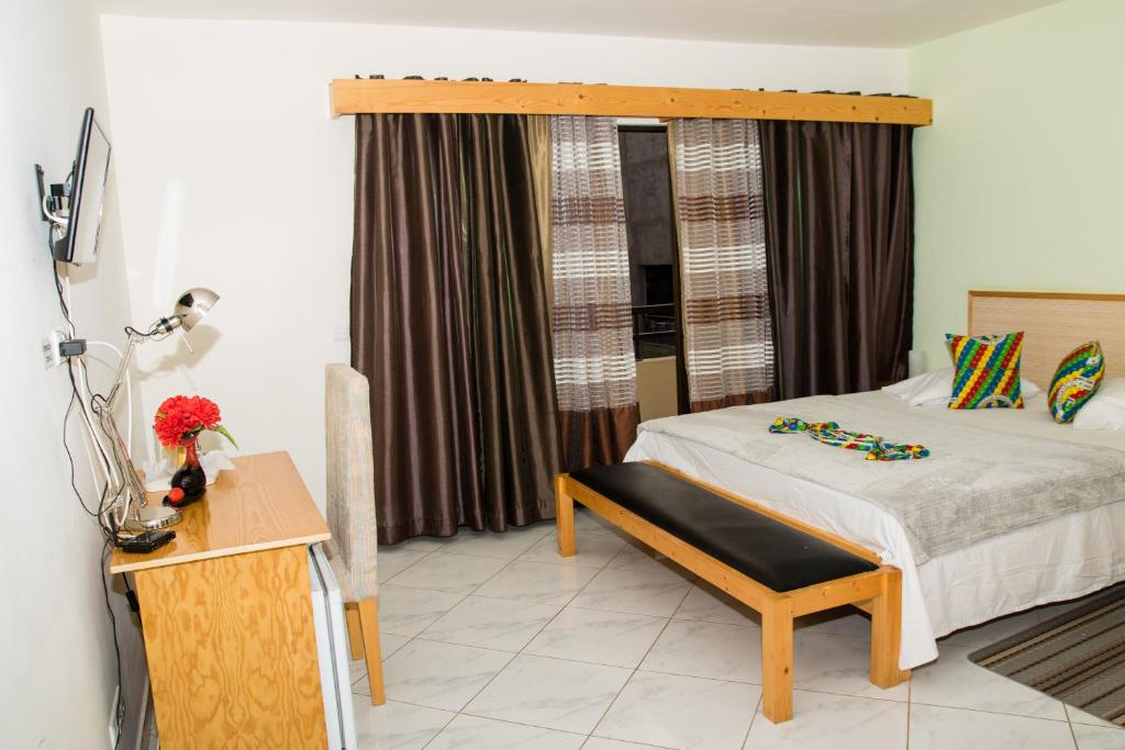 普拉亚LT Aparthotel的一间卧室配有一张带长凳和窗户的床。