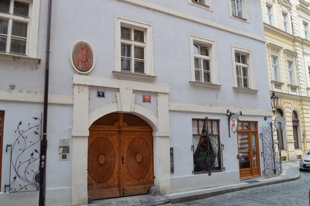 布拉格色温兹多红椅酒店的白色的建筑,在木门上方有一个钟