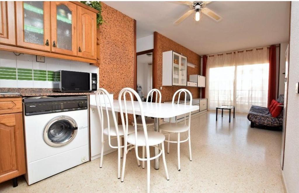 皮内达德马尔Apartamento Pineda的厨房配有桌椅和洗衣机。