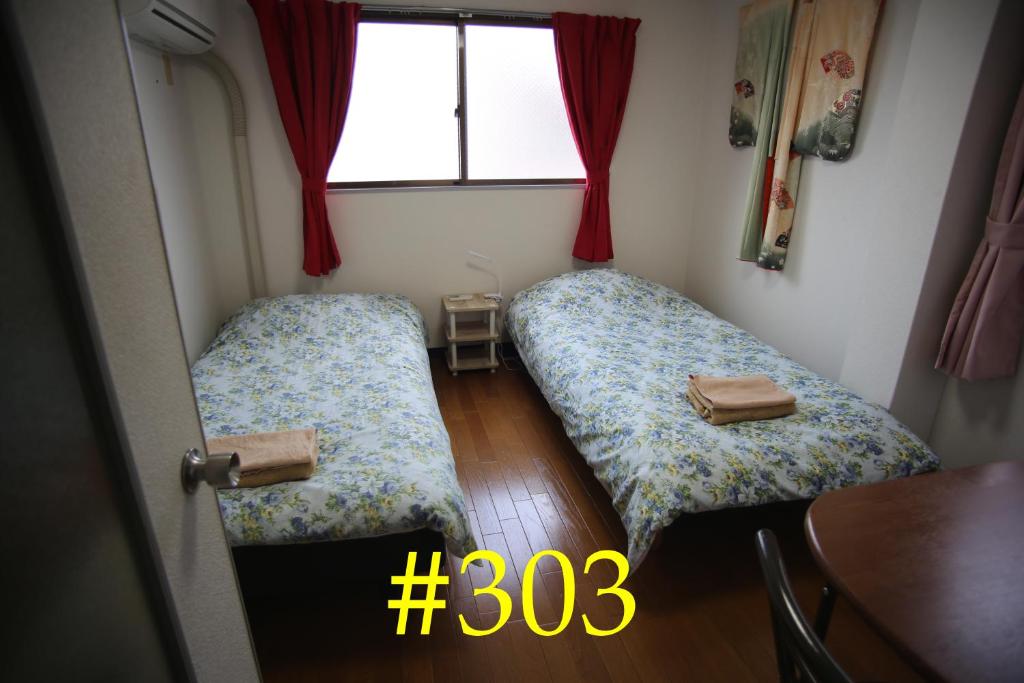 大阪マンションロアジス 大阪市東淀川区相川的小型客房 - 带2张床和窗户