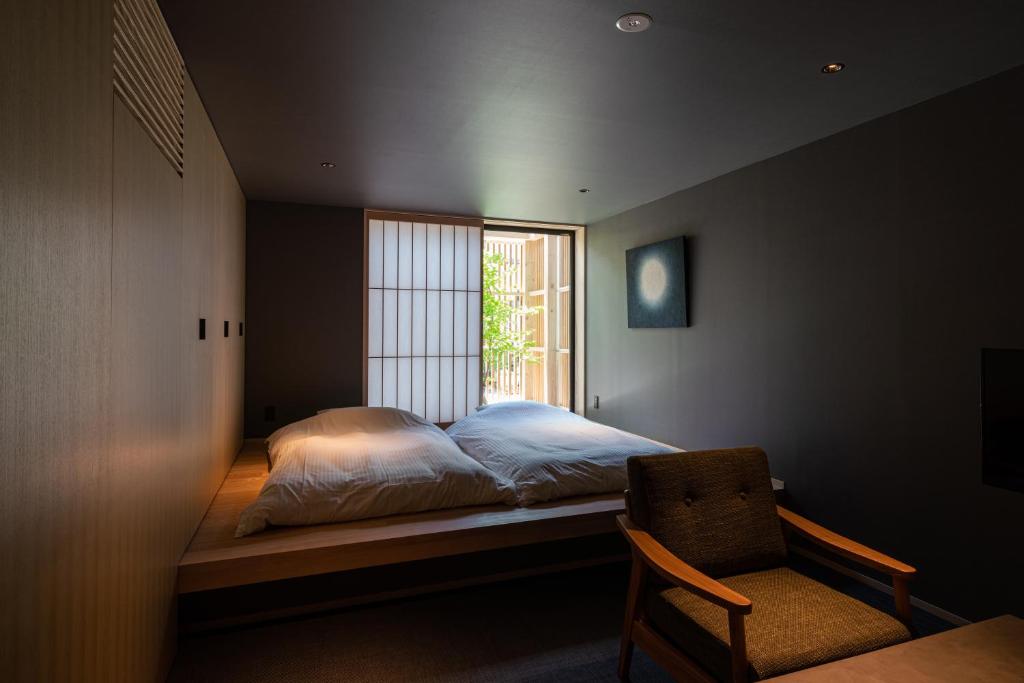 金泽Gunjo no Tsuki的卧室配有床、椅子和窗户。