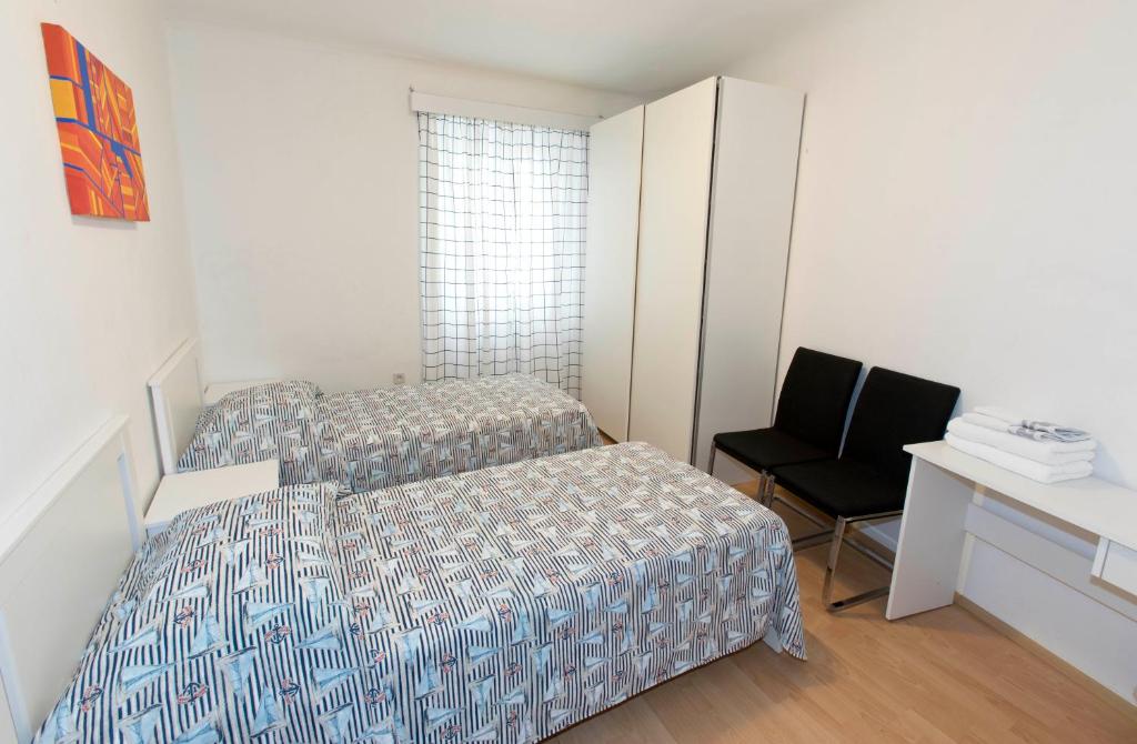 科佩尔Sobe pri Anici的一间卧室配有两张床、一张桌子和一把椅子
